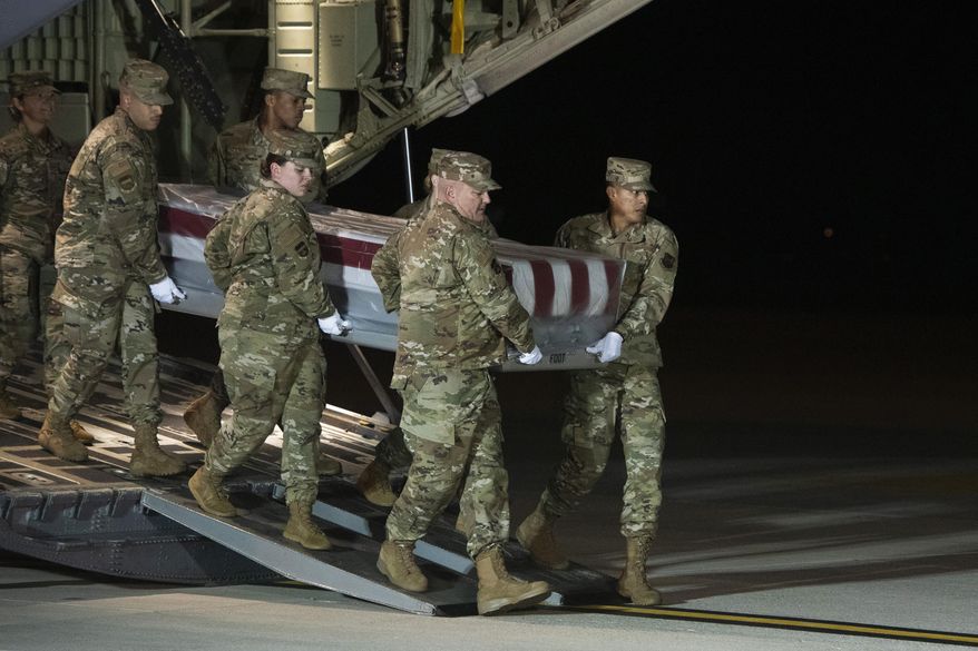 An Air Force carry team moves the transfer case containing the remains of Navy Seaman Apprentice Cameron Scott Walters, of Richmond Hill, Ga., Sunday, Dec. 8, 2019, at Dover Air Force Base, Del. A Saudi gunman killed three people including Walters in a shooting at Naval Air Station Pensacola in Florida. (AP Photo/Cliff Owen)