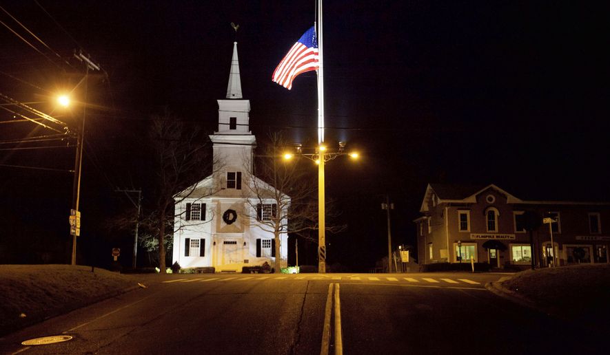 FILE - In this Dec. 15, 2012 file photo, a U.S. flag flies at half-staff on Main Street in Newtown, Conn., in honor of the 26 students and staff killed in a shooting at the Sandy Hook Elementary school. Vigils and church services were held Saturday, Dec. 14, 2019, in Newtown to mark the seventh anniversary of the Dec. 14, 2012, shooting and remember victims of other gun violence. (AP Photo/David Goldman, File)