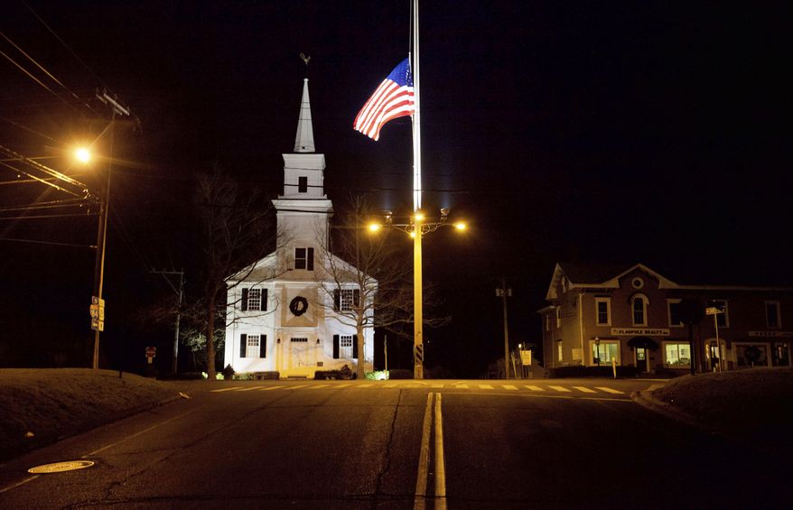FILE - In this Dec. 15, 2012 file photo, a U.S. flag flies at half-staff on Main Street in Newtown, Conn., in honor of the 26 students and staff killed in a shooting at the Sandy Hook Elementary school. Vigils and church services were held Saturday, Dec. 14, 2019, in Newtown to mark the seventh anniversary of the Dec. 14, 2012, shooting and remember victims of other gun violence. (AP Photo/David Goldman, File)