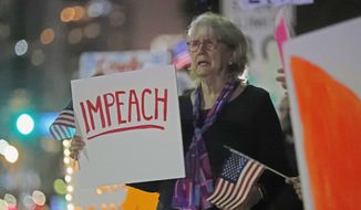 Donna Shelley holds a sign in favor of the impeachment of President Donald Trump, while demonstrating in downtown Miami, Tuesday, Dec. 17, 2019. The House of Representatives is expected to vote Wednesday on articles of impeachment. (AP Photo/Wilfredo Lee)