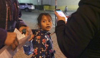 A 7-year-old asylum-seeker waits as her mother Isabel, right, and immigration lawyer Charlene D&#39;Cruz, left, as they figure out where they will be spending the night after being processed at the Port of Entry in Brownsville, Texas, Tuesday, Dec. 17, 2019. The girl who is unable to contain her own waste due to a congenital illness and who had been refused entry to the United States three times has finally been allowed into the country. (AP Photo/Veronica G. Cardenas)
