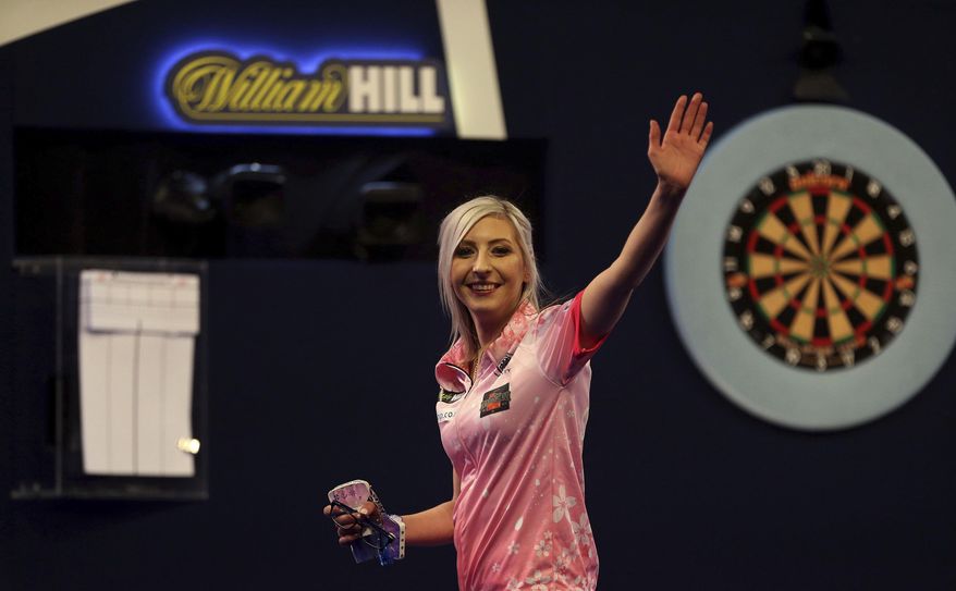 Fallon Sherrock celebrating after becoming the first women to win a game in the PDC Darts World Championship at Alexandra Palace, London, Tuesday Dec. 17, 2019. Sherrock become the first female player to beat a man at the PDC World Championship after she recovered from losing the opening set to beat Ted Evetts 3-2 in front of a raucous crowd at Alexandra Palace. (Steven Paston/PA via AP)