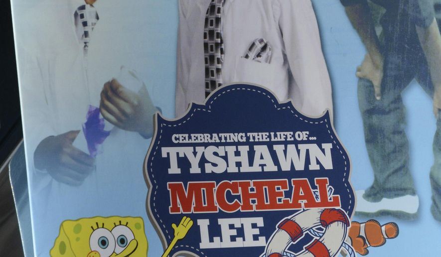 FILE - In this Tuesday, Nov. 10, 2015, file photo, a mourner holds the program for the funeral of 9-year-old Tyshawn Lee at St. Sabina Church in Chicago. A judge on Wednesday, Dec. 18, 2019 handed down decades-long prison sentences to two men who were convicted of first-degree murder in the 2015 slaying of a 9-year-old Chicago boy who was repeatedly shot after being lured into an alley with the promise of a juice box. (Brian Jackson/Chicago Sun-Times via AP, File)