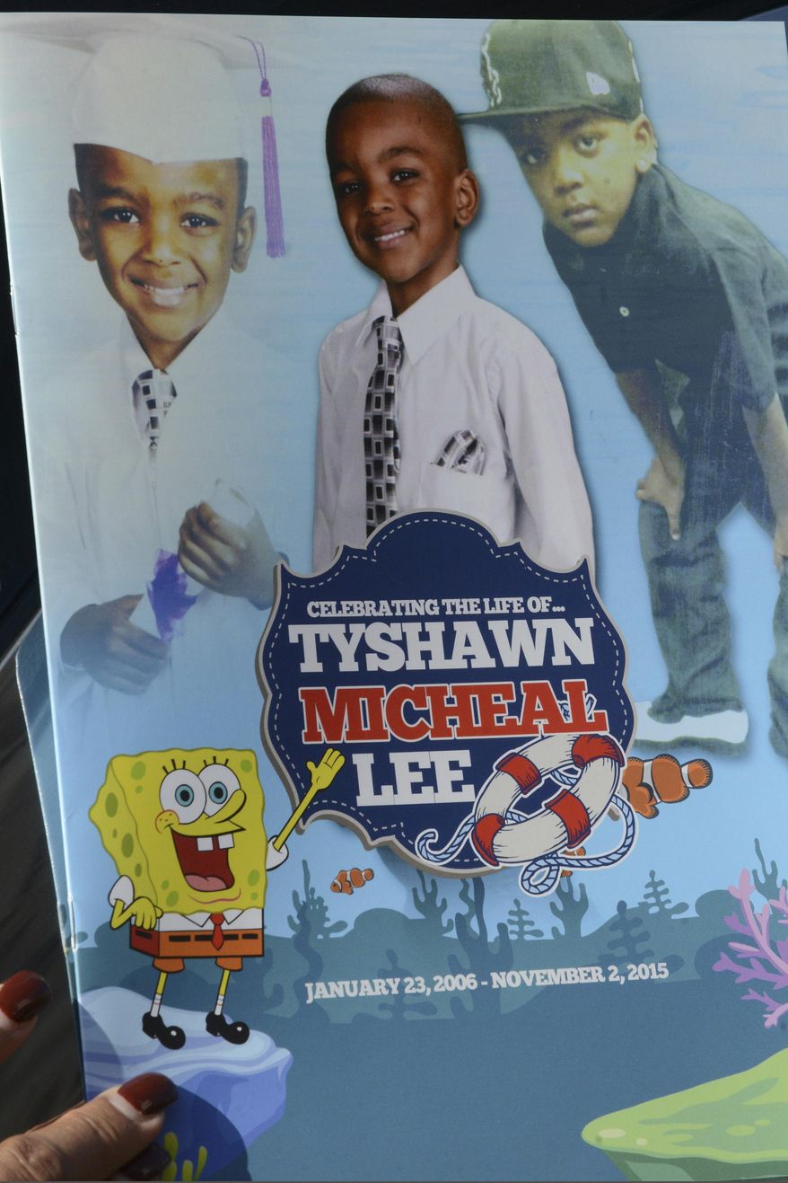 FILE - In this Tuesday, Nov. 10, 2015, file photo, a mourner holds the program for the funeral of 9-year-old Tyshawn Lee at St. Sabina Church in Chicago. A judge on Wednesday, Dec. 18, 2019 handed down decades-long prison sentences to two men who were convicted of first-degree murder in the 2015 slaying of a 9-year-old Chicago boy who was repeatedly shot after being lured into an alley with the promise of a juice box. (Brian Jackson/Chicago Sun-Times via AP, File)