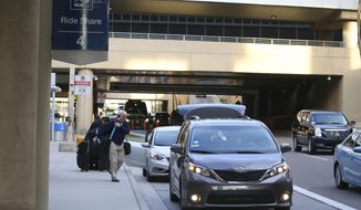 Passengers find their rides at the Ride Share point as they exit Phoenix Sky Harbor International Airport Wednesday, Dec. 18, 2019, in Phoenix. The Phoenix City Council is set to vote on raising fees charged to ride-hailing companies at the airport. If approved Wednesday afternoon, the proposal will increase the current fee from $2.66 per pickup. That would jump to $4 starting Jan. 1 and be applied to drop-offs as well. (AP Photo/Ross D. Franklin)