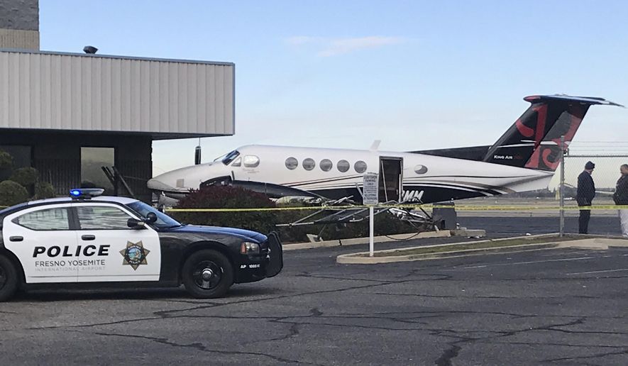 A small plane sits parked after it was crashed into a fence by a 17-year-old girl Wednesday, Dec. 18, 2019, at the Fresno Yosemite International Airport in Fresno, Calif. A spokeswoman for the airport told The Fresno Bee that the teenager breached the fence, started up the plane and crashed it into a fence Wednesday. Airport officials say officers found the teen in the pilot's seat, wearing the headset. No one was injured. The teen was arrested on suspicion of theft of an aircraft. (Jim Guy/The Fresno Bee via AP)