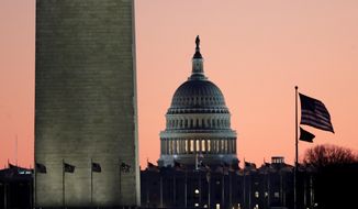 The U.S. Capitol building, center, is seen next to the bottom part of the Washington Monument, left, before sunrise on Capitol Hill in Washington, Thursday, Dec. 19, 2019, a day after the U.S. House voted to impeach President Donald Trump on two charges, abuse of power and obstructing Congress. (AP Photo/Julio Cortez)