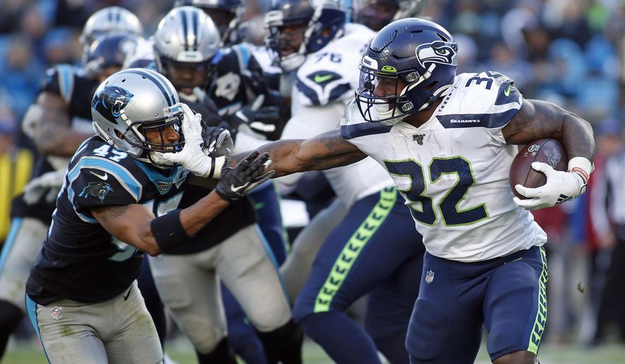 Seattle Seahawks running back Chris Carson (32) runs while Carolina Panthers defensive back Ross Cockrell (47) chases during the second half of an NFL football game in Charlotte, N.C., Sunday, Dec. 15, 2019. (AP Photo/Brian Blanco)