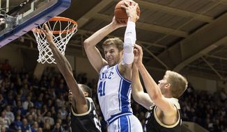 Duke&#x27;s Jack White (41) grabs a rebound between Wofford&#x27;s Messiah Jones, left, and Trevor Stumpe, right, during the first half of an NCAA college basketball game in Durham, N.C., Thursday, Dec. 19, 2019. (AP Photo/Ben McKeown)