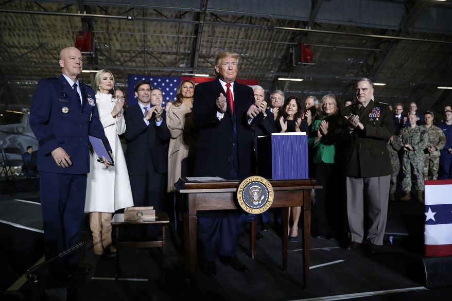 President Donald Trump applauds after signing the National Defense Authorization Act for Fiscal Year 2020 at Andrews Air Force Base, Md., Friday, Dec. 20, 2019, before traveling to Mar-a-lago in Palm Beach, Fla. (AP Photo/Andrew Harnik)
