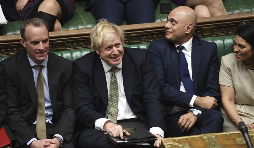 In this photo made available by the UK Parliament, Britain&#x27;s Prime Minister Boris Johnson, center, attends the debate in the House of Commons, London, Thursday Dec. 19, 2019. Boris Johnson signaled an end to Britain’s era of Brexit deadlock Thursday, announcing a packed legislative program intended to take the U.K. out of the European Union on Jan. 31, overhaul everything from fishing to financial services and shore up the country’s cash-starved public services. (Jessica Taylor/UK Parliament via AP)