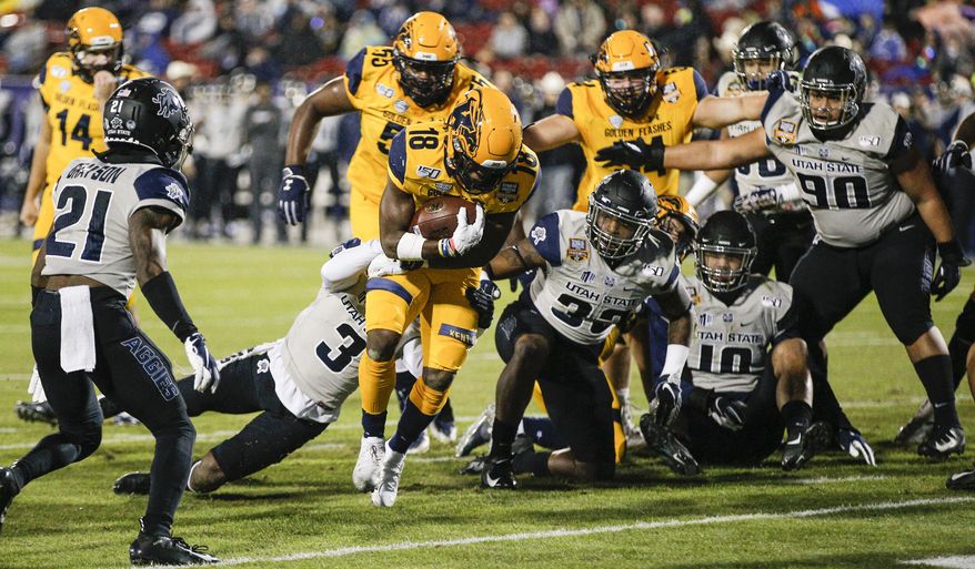 Kent State running back Xavier Williams (18) scores a touchdown as Utah State safety Troy Lefeged Jr. (3) defends during the first half of the Frisco Bowl NCAA college football game Friday, Dec. 20, 2019, in Frisco, Texas. (AP Photo/Brandon Wade)