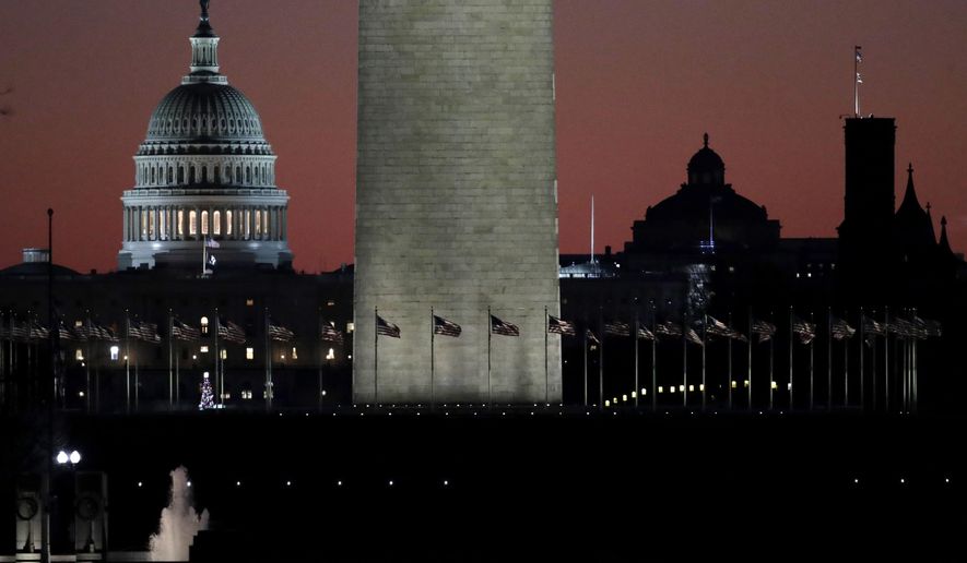 The U.S. Capitol building, is seen next to the bottom portion of the Washington monument, center, before sunrise on Capitol Hill in Washington, Thursday, Dec. 19, 2019, a day after the U.S. House voted to impeach President Donald Trump on two charges, abuse of power and obstructing Congress. (AP Photo/Julio Cortez)