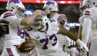 Buffalo Bills quarterback Josh Allen, left, celebrates his touchdown pass to offensive tackle Dion Dawkins, center, in the first half of an NFL football game against the New England Patriots, Saturday, Dec. 21, 2019, in Foxborough, Mass. (AP Photo/Steven Senne)