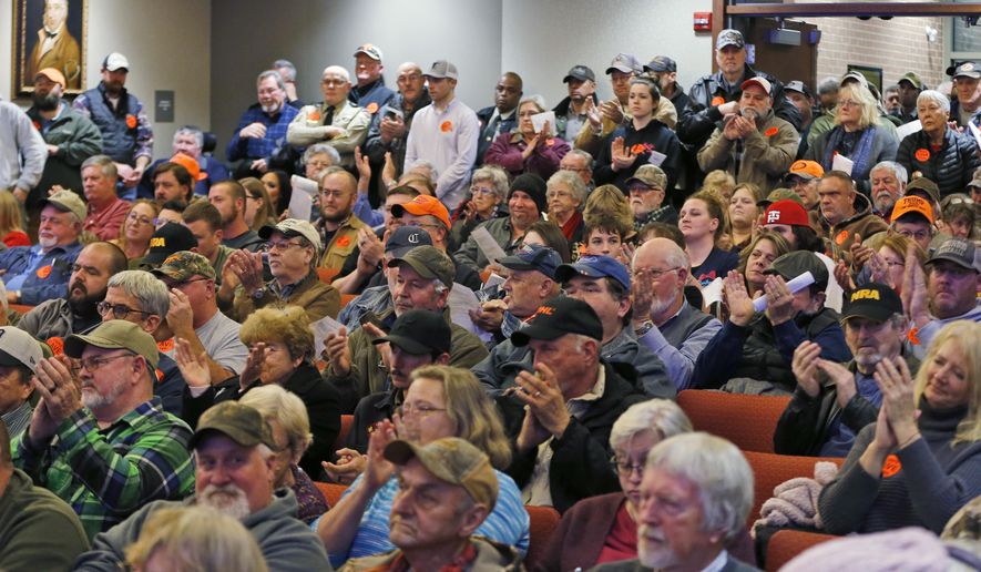Spectators applaud as the Buckingham County Board of Supervisors unanimously voted to pass a Second Amendment Sanctuary City resolution at a meeting in Buckingham , Va., Monday, Dec. 9, 2019. The board passed the resolution without any public discussion. (AP Photo/Steve Helber)