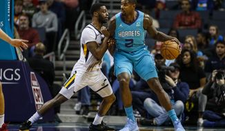 Charlotte Hornets forward Marvin Williams, right, drives into Utah Jazz guard Emmanuel Mudiay in the first half of an NBA basketball game in Charlotte, N.C., Saturday, Dec. 21, 2019. (AP Photo/Nell Redmond)