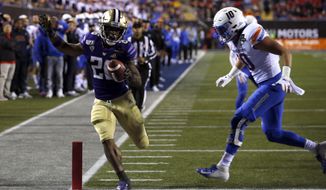 Washington running back Salvon Ahmed, left, makes it into the end zone ahead of Boise State safety Kekoa Nawahine for Washington&#x27;s second touchdown during the first half of the Las Vegas Bowl NCAA college football game at Sam Boyd Stadium, Saturday, Dec. 21, 2019, in Las Vegas. (AP Photo/Steve Marcus)