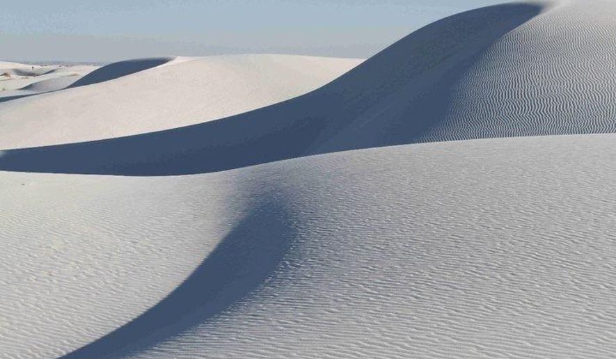 FILE - This March 19, 2011 file photo shows the shifting dunes of White Sands National Monument near Alamogordo, N.M. President Donald Trump's signature on defense legislation enacted by Congress means White Sands National Monument in southern New Mexico is now White Sands National Park. White Sands became the 62nd designated national park Friday, Dec. 20, 2019 with Trump's signing of the National Defense Authorization Act for Fiscal Year 2020, which included a provision on the re-designation, park officials said Saturday in a statement. (AP Photo/Susan Montoya Bryan, file)