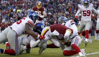 Washington Redskins quarterback Case Keenum (8) pushes his way to score on a keeper as New York Giants defenders, from left, B.J. Hill, Markus Golden and Deone Bucannon try to stop him during the second half of an NFL football game, Sunday, Dec. 22, 2019, in Landover, Md. (AP Photo/Alex Brandon)