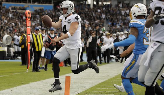 Oakland Raiders quarterback Derek Carr scores against the Los Angeles Chargers during the first half of an NFL football game Sunday, Dec. 22, 2019, in Carson, Calif. (AP Photo/Marcio Jose Sanchez)