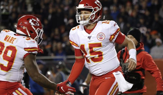 Kansas City Chiefs quarterback Patrick Mahomes (15) celebrates his 12-yard touchdown run with running back Spencer Ware in the first half of an NFL football game against the Chicago Bears in Chicago, Sunday, Dec. 22, 2019. (AP Photo/Nam Y. Huh)