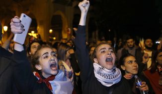 Protesters chant slogans during ongoing protests against the Lebanese political class, in downtown Beirut, Lebanon, Sunday, Dec. 22, 2019. Lebanon&#x27;s new prime minister held consultations Saturday with parliamentary blocs in which they discussed the shape of the future government. The next administration will have to steer the country out of its worst economic and financial crisis in decades. (AP Photo/Bilal Hussein)