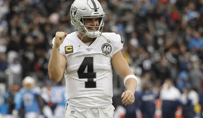 Oakland Raiders quarterback Derek Carr celebrates after a touchdown by running back DeAndre Washington during the second half of an NFL football game against the Los Angeles Chargers Sunday, Dec. 22, 2019, in Carson, Calif. (AP Photo/Marcio Jose Sanchez)