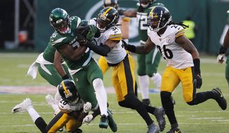 New York Jets running back Le&#39;Veon Bell (26) is stopped by Pittsburgh Steelers strong safety Terrell Edmunds (34) and Pittsburgh Steelers cornerback Mike Hilton (28) in the second half of an NFL football game, Sunday, Dec. 22, 2019, in East Rutherford, N.J. (AP Photo/Seth Wenig)