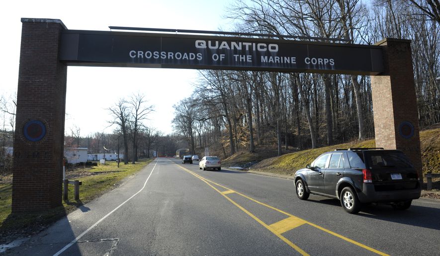 Cars pass under a sign at the entrance to the main gate at Quantico Marine Corps Base in Quantico, Va., Friday, March 22, 2013. (AP Photo/Cliff Owen) ** FILE **