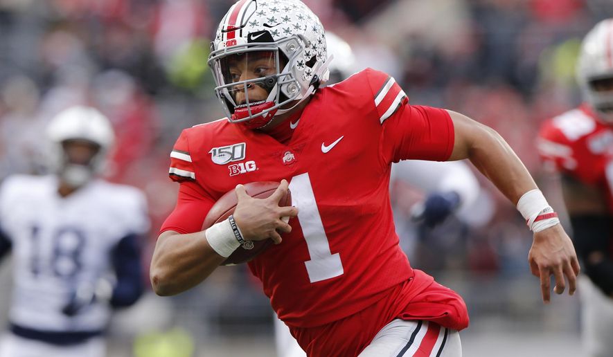 FILE - In this Nov. 23, 2019, file photo, Ohio State quarterback Justin Fields plays against Penn State during an NCAA college football game, in Columbus, Ohio. Fields, a sophomore and the Buckeyes’ Heisman Trophy finalist quarterback, said online classes allow him to split his time between studying at home or relaxing with Netflix and the Woody Hayes Athletic Center, where besides football facilities there is a new lavish lounge for players that offers made-to-order meals, massage chairs, video games on big screens and a cryogenic chamber. (AP Photo/Jay LaPrete, File)