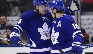 Toronto Maple Leafs right wing Mitch Marner (16) celebrates his second goal of the third period with teammate Auston Matthews (34) during NHL hockey action in Toronto, Monday, Dec. 23, 2019. (Frank Gunn/The Canadian Press via AP)