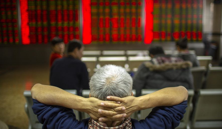 Chinese investors monitor stock prices at a brokerage house in Bejiing, Thursday, Dec. 26, 2019. Shares are mostly higher in Asia with many world markets closed for Christmas holidays. (AP Photo/Mark Schiefelbein)
