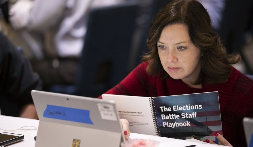 In this Monday, Dec. 16, 2019, photo, Mandy Vigil, from New Mexico, works during an exercise run by military and national security officials, for state and local election officials to simulate different scenarios for the 2020 elections, in Springfield, Va. These government officials are on the front lines of a different kind of high-stakes battlefield, one in which they are helping to defend American democracy by ensuring free and fair elections. (AP Photo/Alex Brandon)