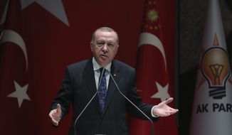 Turkey&#39;s President Recep Tayyip Erdogan addresses the members of his ruling party, in Ankara, Turkey, Thursday, Dec. 26, 2019. Erdogan says Thursday his government will submit a bill to parliament that would allow Turkey to send troops to Libya, in support of the U.N.-backed government there. Erdogan said the Libyan government, which controls the capital, Tripoli, has &quot;invited&quot; Turkey to send troops. (Turkish Presidency via AP, Pool)