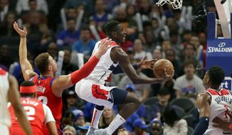 Washington Wizards guard Isaac Bonga, center, goes to the basket past Detroit Pistons forward Blake Griffin (23) during the first half of an NBA basketball game Thursday, Dec. 26, 2019, in Detroit. (AP Photo/Duane Burleson)