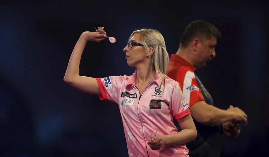 Fallon Sherrock and Mensur Suljovic in action during day nine of the William Hill World Championships at Alexandra Palace, London, Saturday Dec. 21, 2019. (Steven Paston/PA via AP)