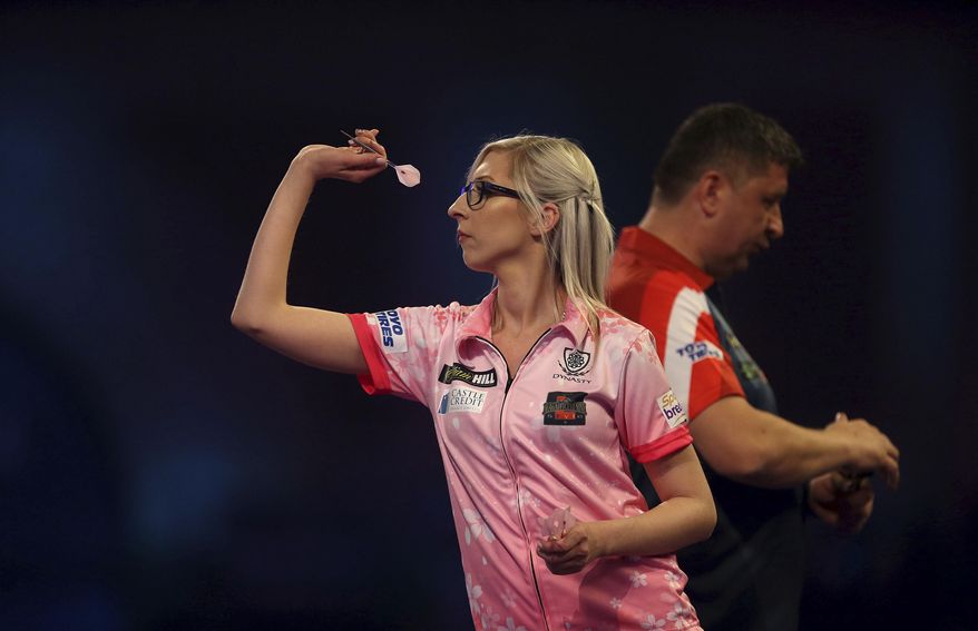 Fallon Sherrock and Mensur Suljovic in action during day nine of the William Hill World Championships at Alexandra Palace, London, Saturday Dec. 21, 2019. (Steven Paston/PA via AP)