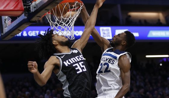Minnesota Timberwolves forward Andrew Wiggins, right, stuffs over Sacramento Kings forward Marvin Bagley III during the first quarter of an NBA basketball game in Sacramento, Calif., Thursday, Dec. 26, 2019. (AP Photo/Rich Pedroncelli)
