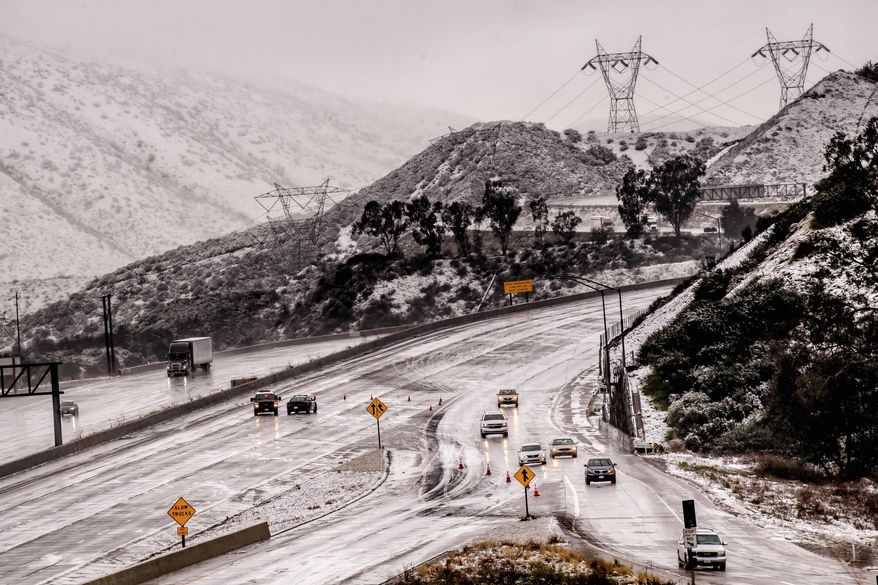 Vehicles are diverted off the northbound 15 Freeway to Kenwood Ave. on-ramp as Cajon Pass is shut down due to heavy snowfall in San Bernardino, Calif., on Thursday, Dec. 26, 2019. (Watchara Phomicinda/The Orange County Register via AP)