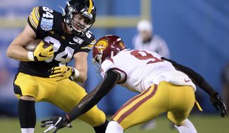 Iowa tight end Sam LaPorta (84) runs with the ball while defended by Southern California cornerback Greg Johnson (9) during the first half of the Holiday Bowl NCAA college football game Friday, Dec. 27, 2019, in San Diego. (AP Photo/Orlando Ramirez)