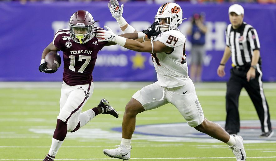 Texas A&M wide receiver Ainias Smith (17) fends off Oklahoma State defensive end Trace Ford (94) during the first half of the Texas Bowl NCAA college football game Friday, Dec. 27, 2019, in Houston. (AP Photo/Michael Wyke)
