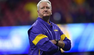 LSU Offensive Coordinator Steve Ensminger watches teams warm up before the first half of the Peach Bowl NCAA semifinal college football playoff game between LSU and Oklahoma, Saturday, Dec. 28, 2019, in Atlanta. Ensminger&#x27;s daughter-in-law, Carley McCord, died in a plane crash Saturday in Louisiana on the way to the game. (AP Photo/John Amis)