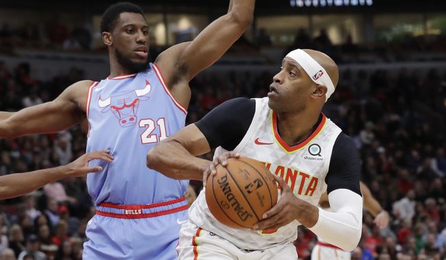 Atlanta Hawks guard/forward Vince Carter, right, looks to pass as Chicago Bulls forward Thaddeus Young guards during the first half of an NBA basketball game Saturday, Dec. 28, 2019, in Chicago. (AP Photo/Nam Y. Huh)