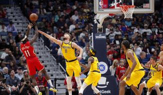 New Orleans Pelicans guard Jrue Holiday (11) shoots against Indiana Pacers forward Domantas Sabonis (11) during the first half of an NBA basketball game in New Orleans, Saturday, Dec. 28, 2019. (AP Photo/Gerald Herbert)