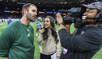 In this Dec. 14, 2019 photo Acadiana head coach Matt McCullough, left, speaks with Carley McCord, center, following a win over the Destrehan in the State Division 5A Championship football game in Lafayette, La. One of victims in a deadly Louisiana plane crash was a sports reporter and daughter-in-law of a Louisiana State University football coach. Steven Ensminger Jr. says his wife, Carley McCord, died in the crash in Louisiana on Saturday, Dec. 28, on the way to a college football playoff game in Atlanta. (Scott Clause/The Daily Advertiser via AP)
