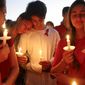 FILE- In this Feb. 15, 2018, file photo, students gather during a vigil at Pine Trails Park for the victims of a shooting at Marjory Stoneman Douglas High School, in Parkland, Fla. Nikolas Cruz, a former student, was charged with 17 counts of premeditated murder. For Florida, the 2010s were a decade of high-profile mass shootings at a nightclub, high school, airport and naval base, leaving 74 victims dead. (AP Photo/Brynn Anderson, File)