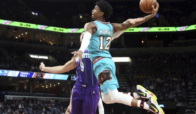 Memphis Grizzlies guard Ja Morant (12) goes up to shoots while defended by Charlotte Hornets center Willie Hernangomez (9) in the second half of an NBA basketball game Sunday, Dec. 29, 2019, in Memphis, Tenn. (AP Photo/Karen Pulfer Focht)