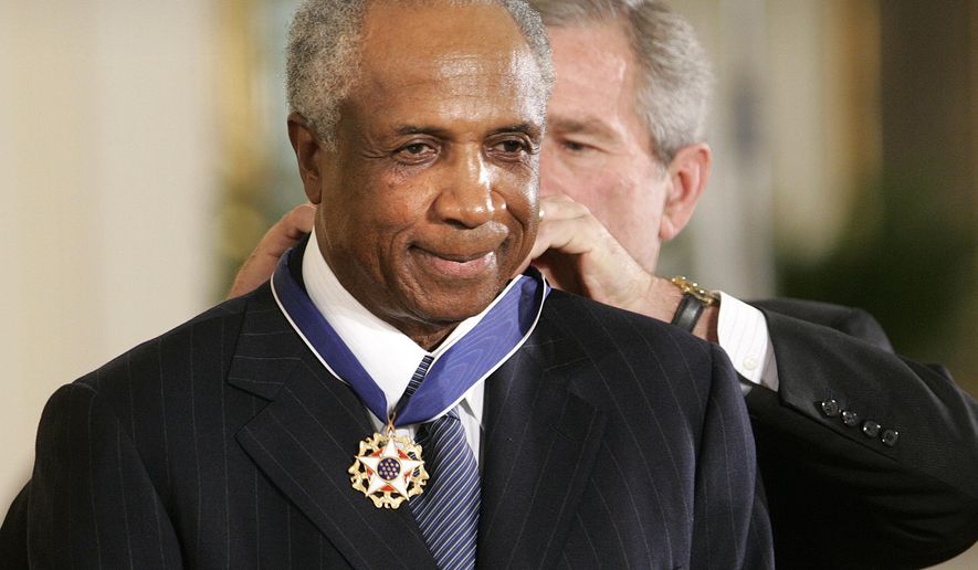 FILE - In this Nov. 9, 2005, file photo, President Bush awards baseball legend Frank Robinson the Presidential Medal of Freedom Award in the East Room of the White House in Washington. Hall of Famer Frank Robinson, the first black manager in Major League Baseball and the only player to win the MVP award in both leagues, died Feb. 7, 2019. He was 83. (AP Photo/Lawrence Jackson, File)