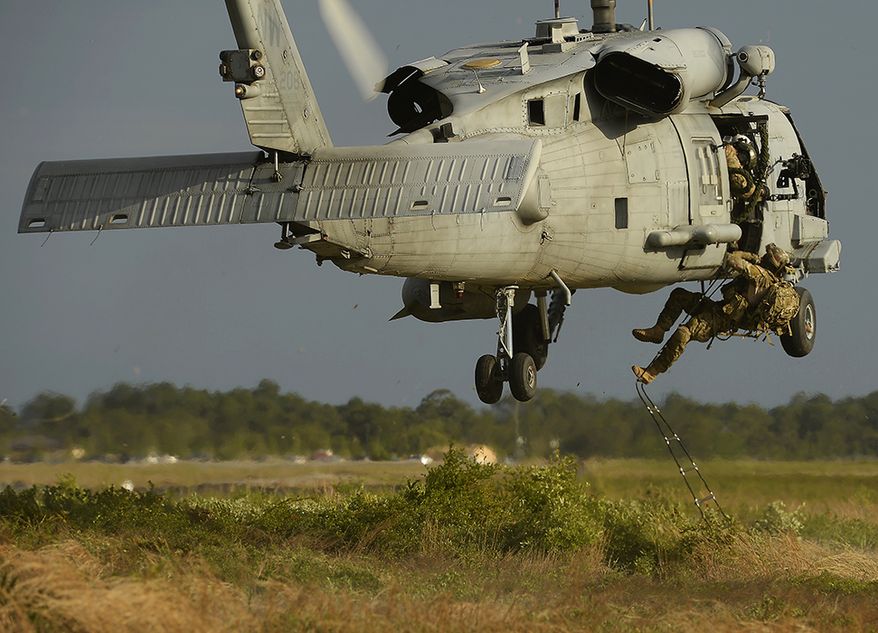 A Navy HH-60H Seahawk from the Helicopter Sea Combat Squadron84, extracts Air Force combat controllers during Emerald Warrior, May 2, 2014, at Hurlburt Field, Fla. Emerald Warrior is an annual, joint exercise to train special operations, conventional and partner nation forces in combat scenarios designed to hone special operations air and ground combat skills, and is the Department of Defenses only irregular warfare exercise. (U.S. Air Force photo/Staff Sgt. Tim Chacon)