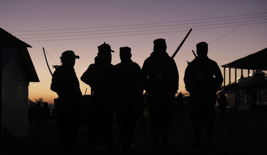 Female members of the Zapatista militia, carrying bows and arrows, wait for coffee at sunrise during a gathering titled The Second International Meeting of Women Who Fight, organized by the women of the Zapatista National Liberation Army (EZLN) in Caracol Morelia, Altamirano municipality, Chiapas state, Mexico, Friday, Dec. 27, 2019. The Zapatistas have self-governed over a large swath of Mexico's southern-most state since the rebels rose up in arms to demand greater indigenous rights in January 1994. (AP Photo/Isabel Mateos)